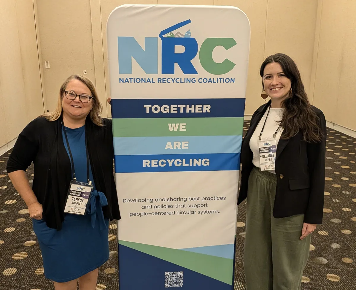 Two NRC attendees beside the Together We Are Recycling banner at the 2026 Circularity Forum